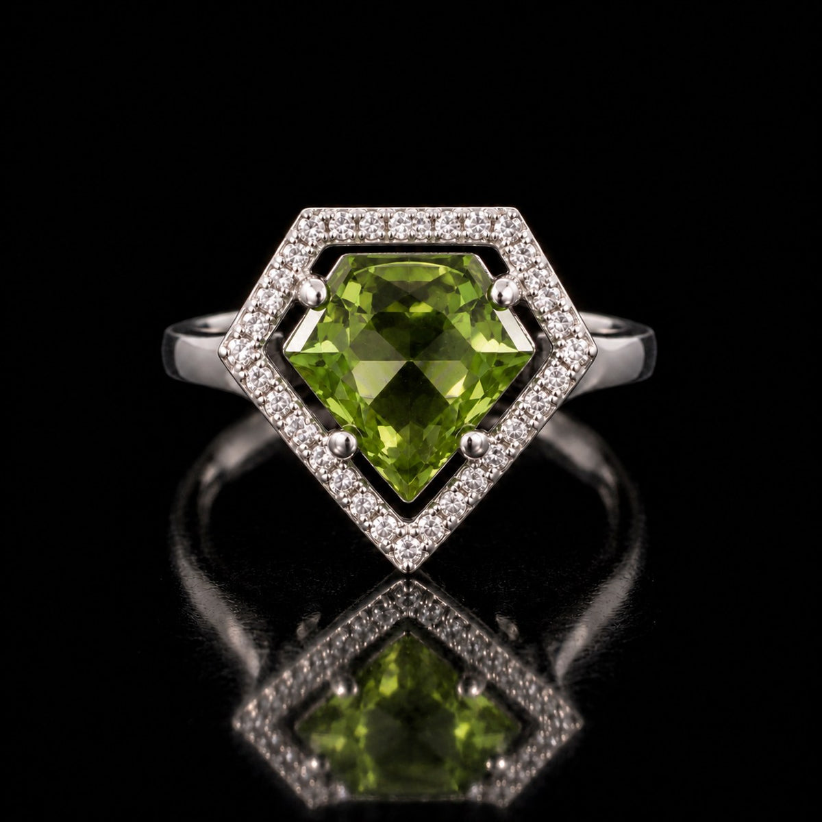 The same VooDooStone shield-cut halo ring turning peridot green under fluorescent light, front view. Item 894784.