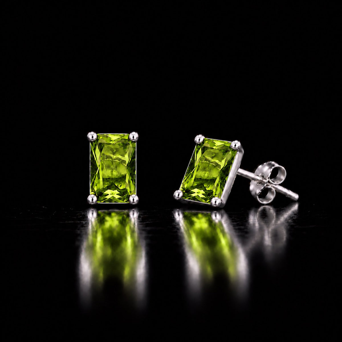 The same VooDooStone emerald-cut stud earrings turning peridot green under fluorescent light. Item 894789.