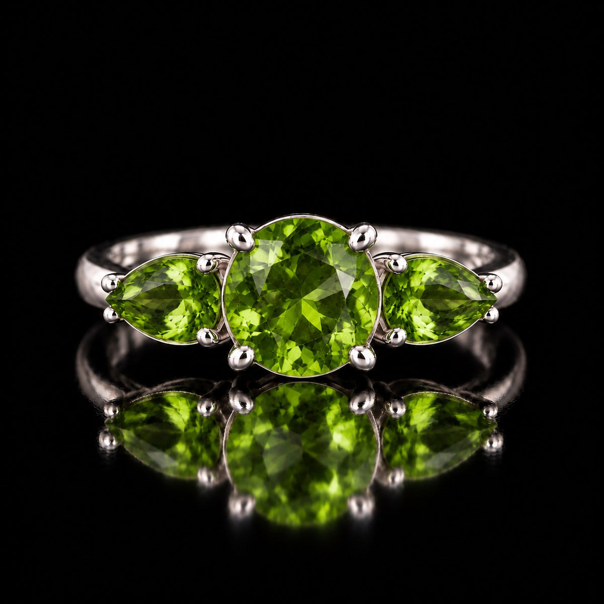 The same VooDooStone three-stone ring turning peridot green under fluorescent light, front view. Item 894786.